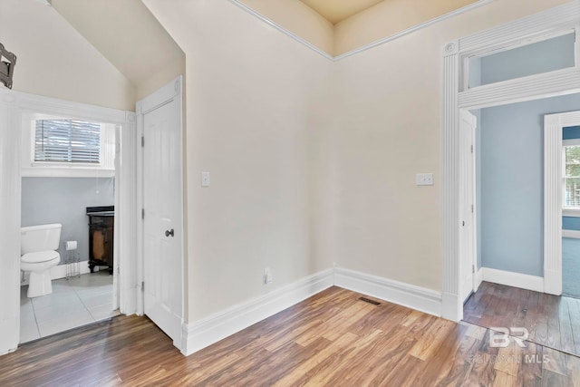 interior space featuring baseboards, wood finished floors, and visible vents