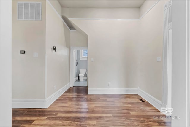 interior space with baseboards, visible vents, and wood finished floors