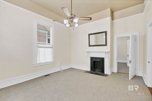 unfurnished living room with carpet floors, a fireplace with flush hearth, ceiling fan, and visible vents