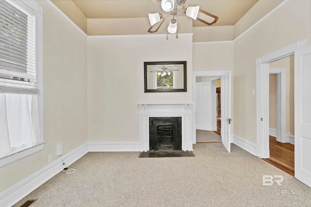 unfurnished living room featuring a fireplace with flush hearth, plenty of natural light, and carpet