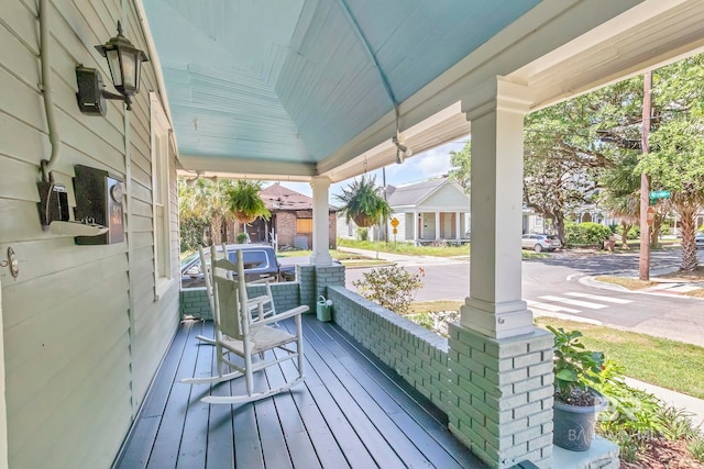 wooden deck featuring a residential view and covered porch