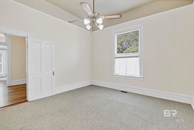 carpeted empty room with a ceiling fan, baseboards, and visible vents
