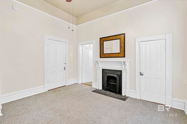 unfurnished living room with carpet flooring, a fireplace with flush hearth, and a towering ceiling