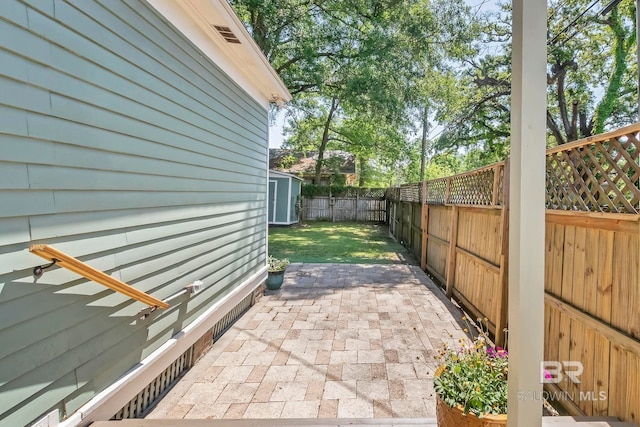 view of patio / terrace featuring a fenced backyard, an outbuilding, and a storage shed