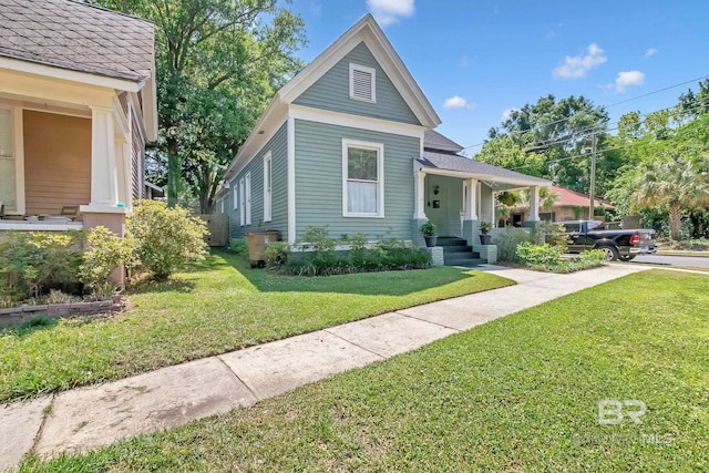 view of front of home featuring a shingled roof and a front lawn