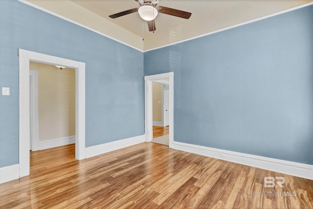 empty room featuring baseboards, a ceiling fan, and wood finished floors