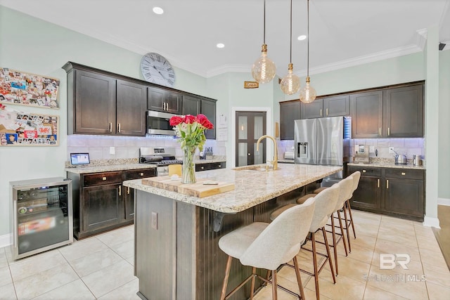 30635 Drayton Ct, Spanish Fort, AL 36527 - kitchen with wine cooler, appliances with stainless steel finishes, a sink, light tile patterned flooring, and ornamental molding
