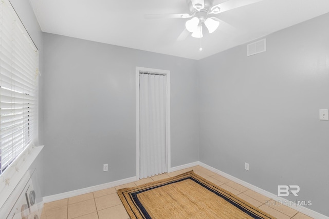 tiled empty room with ceiling fan