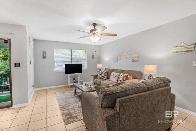 living room featuring a textured ceiling, ceiling fan, and light tile patterned floors