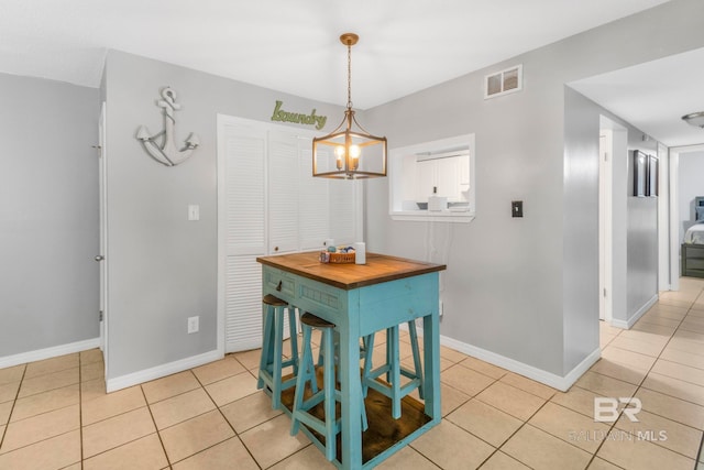 dining space featuring light tile patterned floors and a chandelier