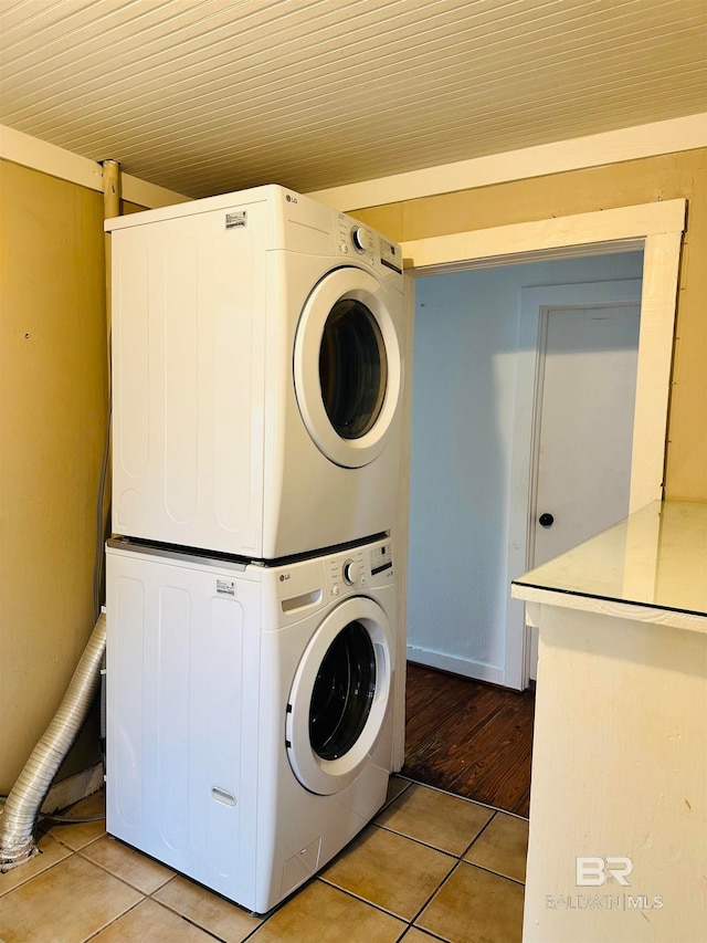 laundry room featuring light tile patterned floors and stacked washer / dryer