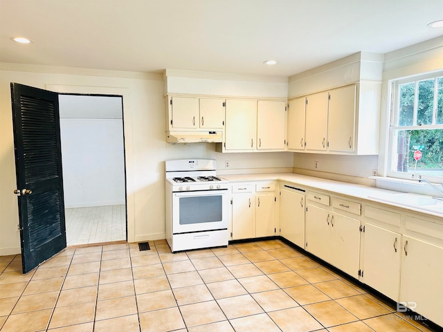 kitchen with light tile patterned floors, white cabinetry, sink, and white range with gas cooktop