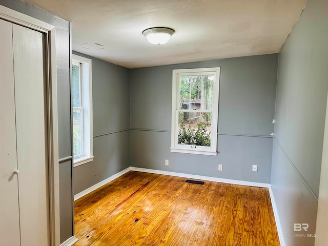 unfurnished room with wood-type flooring