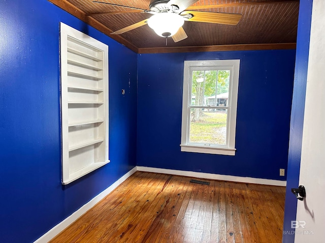 spare room featuring wood-type flooring, wooden ceiling, and ornamental molding