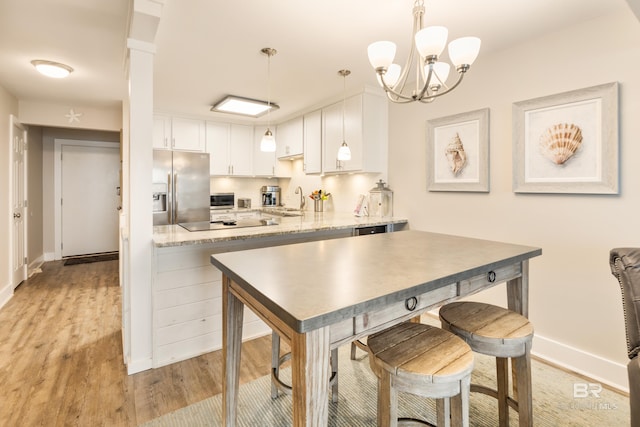 kitchen featuring light wood-style flooring, a sink, backsplash, white cabinetry, and stainless steel fridge with ice dispenser