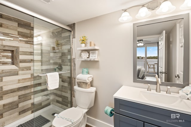 bathroom with vanity, toilet, baseboards, and a stall shower