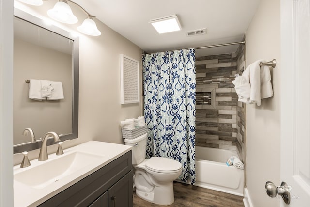 full bathroom featuring visible vents, shower / tub combo with curtain, toilet, wood finished floors, and vanity