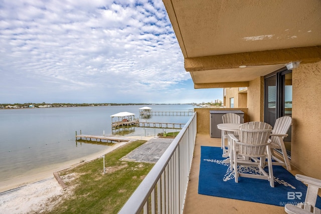 balcony with a water view and a boat dock