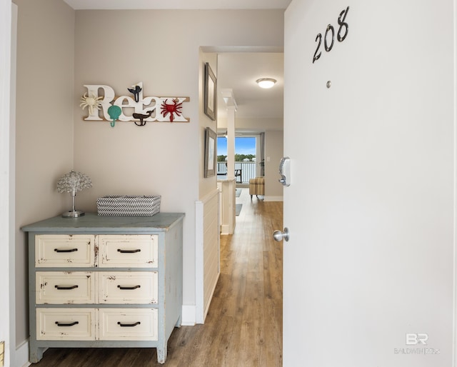 corridor featuring wood finished floors and baseboards