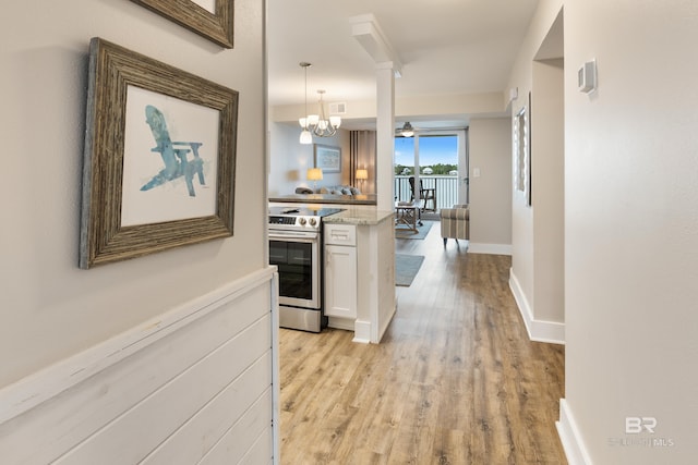 corridor featuring visible vents, baseboards, and light wood-style flooring