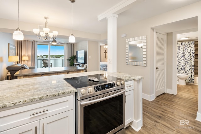 kitchen with light wood-style flooring, stainless steel range with electric cooktop, white cabinets, and light stone countertops