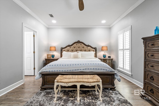 bedroom with crown molding, wood finished floors, baseboards, and visible vents