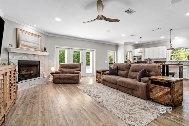 living room featuring a wealth of natural light, visible vents, and ceiling fan