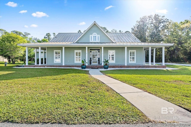country-style home with metal roof, a front yard, a standing seam roof, and covered porch