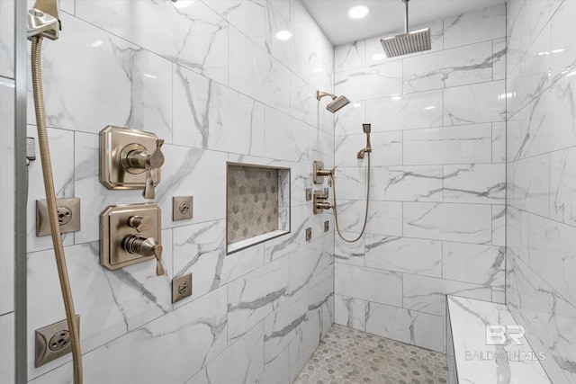 bathroom with tiled shower and visible vents