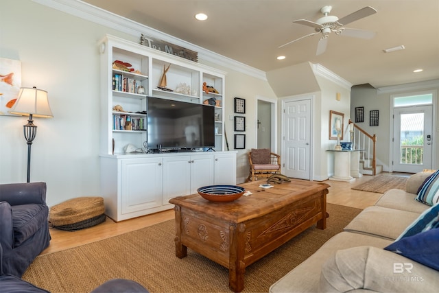 living room with hardwood / wood-style floors, crown molding, and ceiling fan