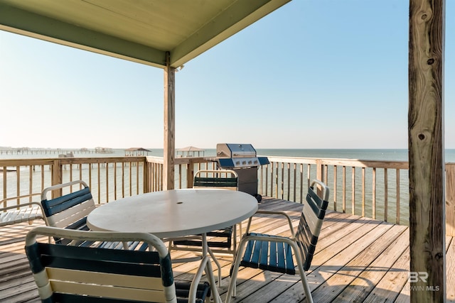 deck with a water view and area for grilling