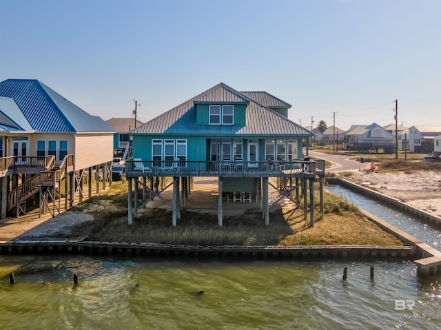 rear view of property featuring a deck with water view