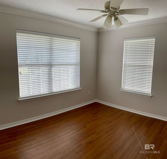 spare room featuring ceiling fan, dark hardwood / wood-style floors, plenty of natural light, and a textured ceiling