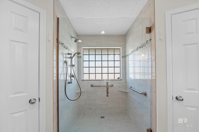 bathroom featuring a shower with shower door and a textured ceiling