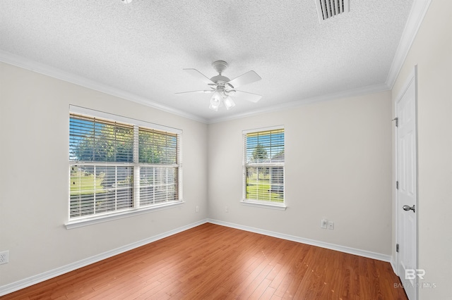 unfurnished room with a wealth of natural light, ornamental molding, and wood-type flooring