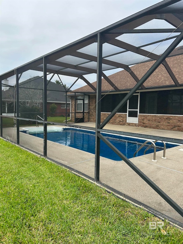 view of swimming pool featuring a patio area, a lanai, and a lawn