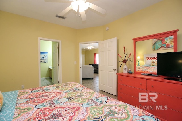 bedroom with ceiling fan, visible vents, connected bathroom, and light tile patterned flooring