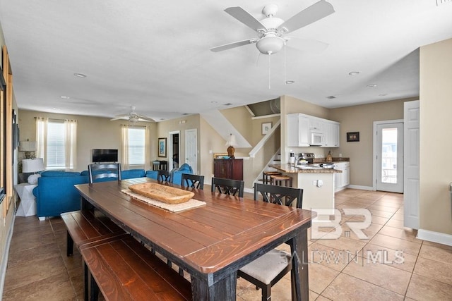 tiled dining space featuring ceiling fan