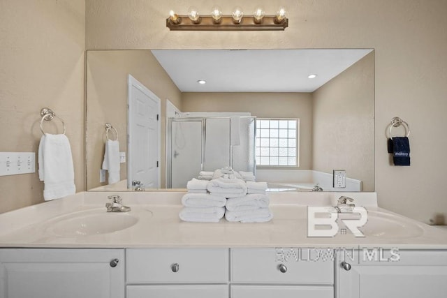 bathroom featuring double sink vanity and separate shower and tub