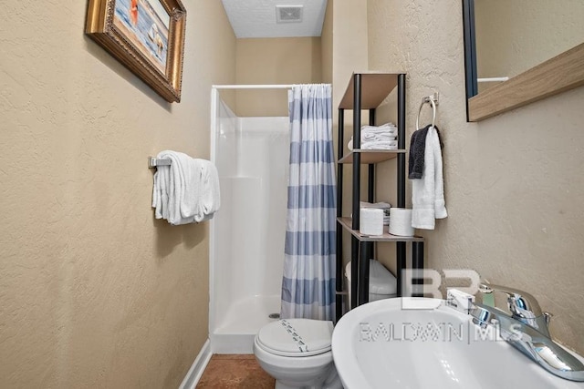 bathroom with sink, tile floors, a shower with shower curtain, and toilet