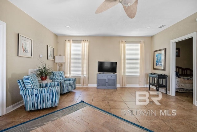living room with light tile flooring and ceiling fan