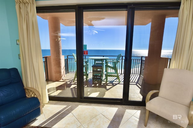 doorway to outside with a water view and light tile patterned floors