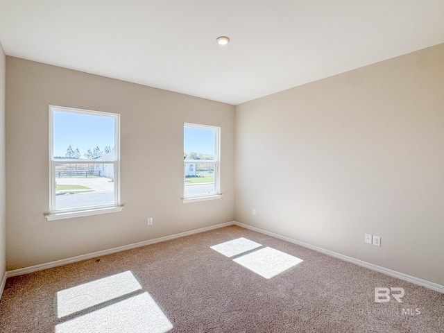 unfurnished room with carpet and baseboards