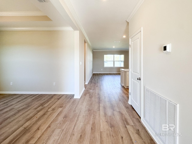 interior space featuring light wood-style flooring, visible vents, crown molding, and baseboards