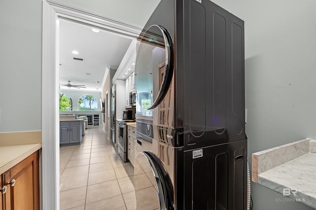 8160 Bay View Dr, Foley, AL 36535 - kitchen with stacked washing machine and dryer, appliances with stainless steel finishes, light tile patterned floors, light countertops, and ceiling fan
