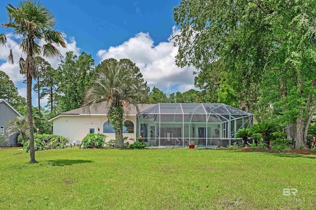 8160 Bay View Dr, Foley, AL 36535 - rear view of house with a lawn, glass enclosure, and stucco siding