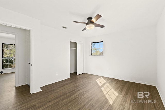 unfurnished bedroom featuring a closet, ceiling fan, and dark hardwood / wood-style flooring