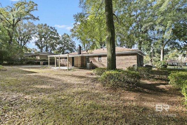 rear view of house with a yard and central air condition unit