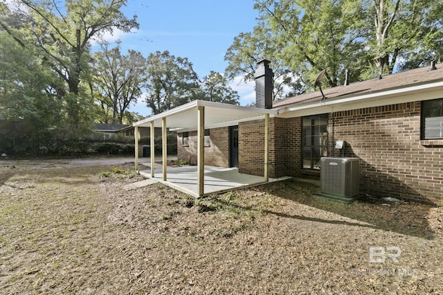 view of yard with central air condition unit and a patio