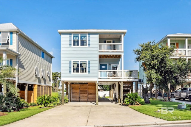 beach home featuring a balcony, a front lawn, and a carport